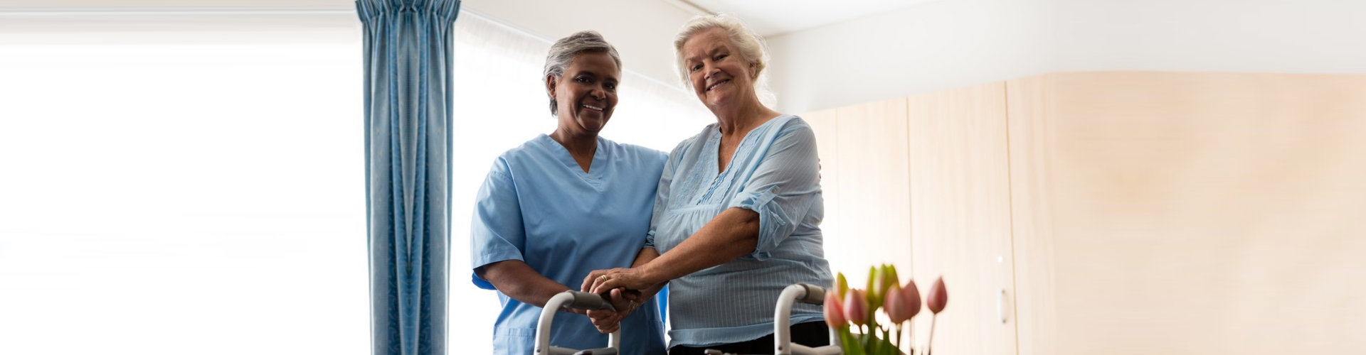 caregiver assisting senior woman to stand